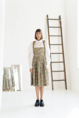 Stüdyoda poz veren eski moda elbiseli muhteşem genç kadın.