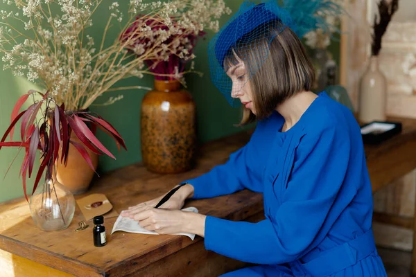 穿着蓝色老式衣服的年轻女子在写便条 — 图库照片