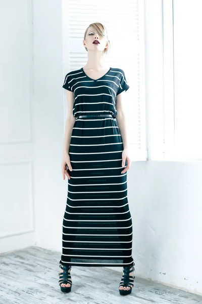 Vrouw in een zwart gestreepte jurk — Stockfoto
