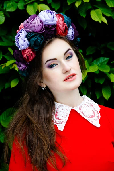 Vrouw in rode doek met een bloem krans — Stockfoto