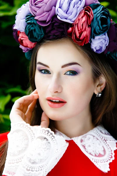 Mujer en tela roja con una corona de flores — Foto de Stock