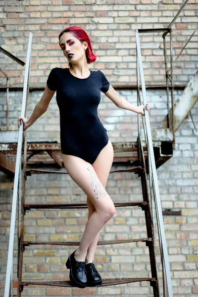 Femme attrayante posant sur des escaliers en métal — Photo