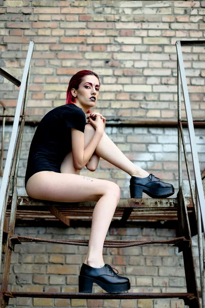 Attractive woman posing on metal stairs — Stok fotoğraf