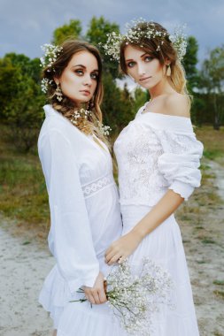 Beyaz elbiseler içinde iki kadın