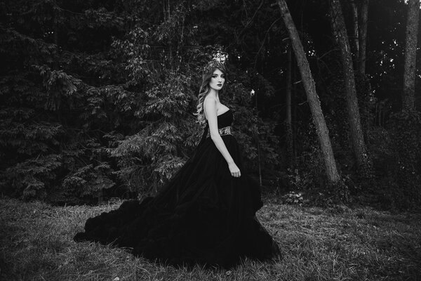 Beautiful woman in gorgeous black dress outdoors . Full length Portrait.