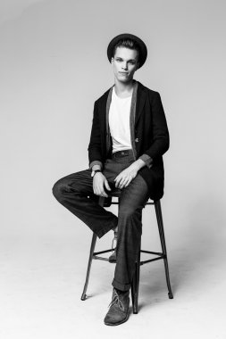 Genç adam sandalyede oturuyor.