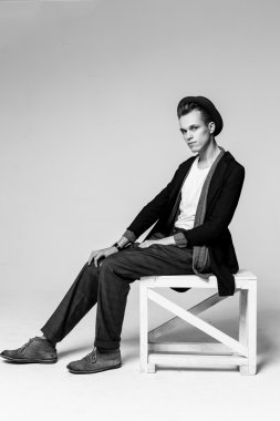 Genç adam sandalyede oturuyor.