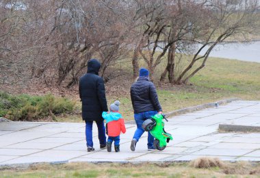 Bahar parkında yürüyüş yapan dost bir aile.