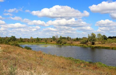 Mavi gökyüzünde bulutlarla yaz manzarası