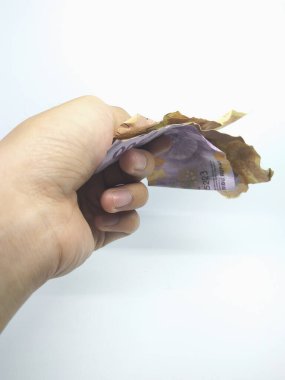 Sol el, beyaz arka planda izole edilmiş buruşuk para verir