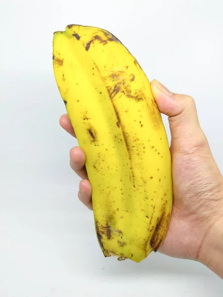 1つの果実に2つの内容があるユニークなバナナを手に持っています 孤立した白い背景を持ち — ストック写真
