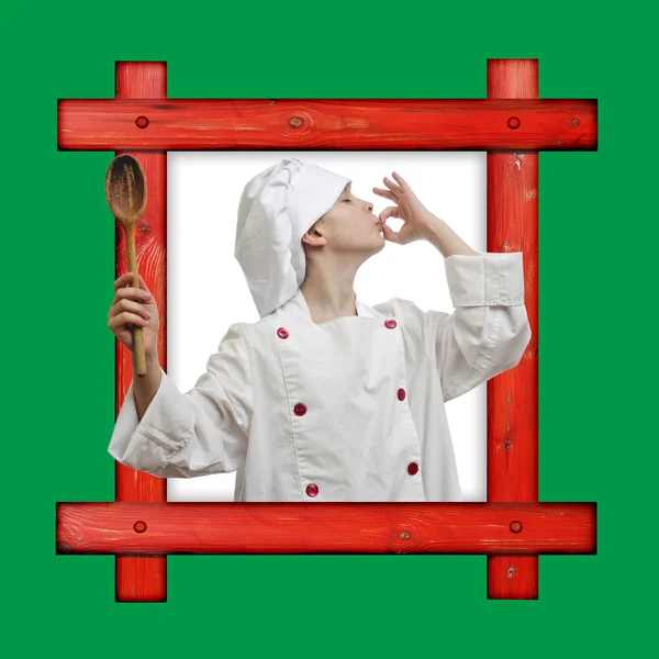 Vecchio telaio in legno su sfondo verde con un giovane ragazzo vestito da chef con cucchiaio di legno su sfondo bianco . — Foto Stock