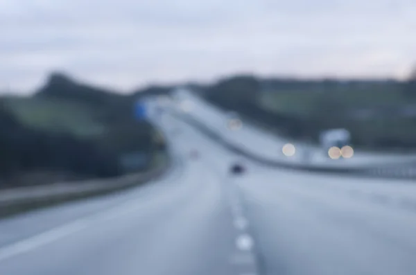 Abstract blurred cars lights dangerous highway driving on wet rainy and foggy day. Rainy and foggy conditions on the highway. Motion blur visualizes the speed and dynamics. — Stock Photo, Image