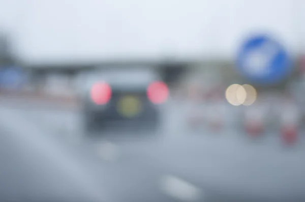 Abstrato carro embaçado estrada perigosa dirigindo no dia chuvoso molhado e nebuloso. Condições de chuva e nevoeiro na auto-estrada. Desfoque de movimento visualiza a velocidade e dinâmica . — Fotografia de Stock