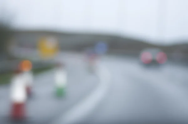 Abstrato carro embaçado estrada perigosa dirigindo no dia chuvoso molhado e nebuloso. Condições de chuva e nevoeiro na auto-estrada. Desfoque de movimento visualiza a velocidade e dinâmica . — Fotografia de Stock