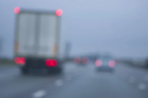 Abstract blurred cars, lorry dangerous highway driving on wet rainy and foggy day. Rainy and foggy conditions on the highway. Motion blur visualizes the speed and dynamics. — Stock Photo, Image