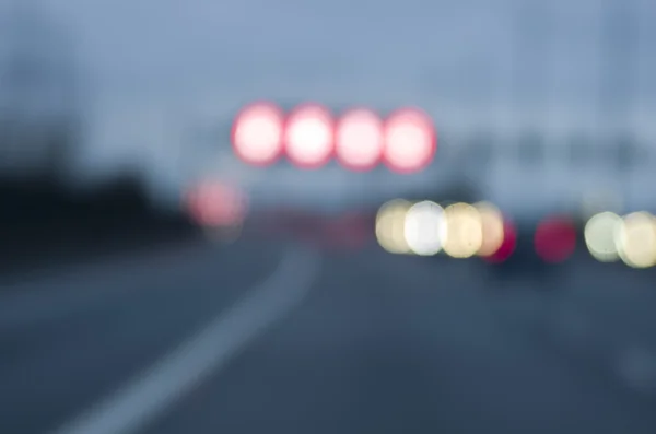Carros embaçados abstratos iluminam estrada perigosa dirigindo no dia chuvoso e nebuloso molhado. Condições de chuva e nevoeiro na auto-estrada. Desfoque de movimento visualiza a velocidade e dinâmica . — Fotografia de Stock