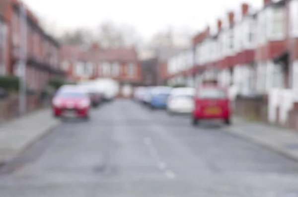 Carretera borrosa con coches y casas en Manchester, Inglaterra . — Foto de Stock