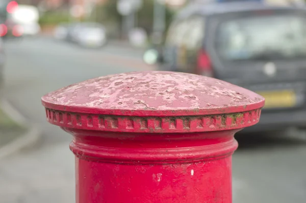 Červená anglická pilíř poštovní schránka nebo pole nahoře na pozadí prostoru města. — Stock fotografie
