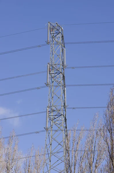 Hög spänning kraftledningar korsar varandra en stor metall Utility stolpe i Manchester England mot en blå himmel. — Stockfoto