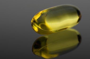 Morina karaciğer D vitamini kapsülü siyah yansıtıcı yüzeyi