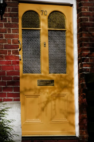 Porte d'entrée jaune d'une maison de ville anglaise en brique rouge. Manchester . — Photo