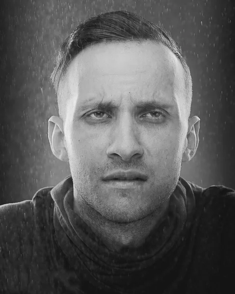 Portrait of mature man under the spindrift, rain studio shoot  on blue background. — Stock Photo, Image
