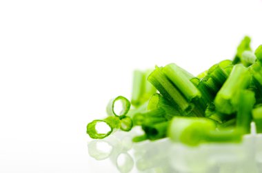 Kıyılmış taze yeşil beyaz arka plan yansıması ile izole soğan.