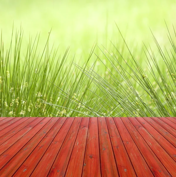 Perspektif kosong kayu merah di atas juncus effusus dalam hujan dan sinar matahari dengan latar belakang bokeh, untuk tampilan produk montase. Inggris, musim panas . — Stok Foto