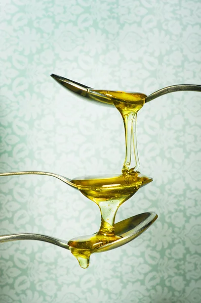 Close up of honey dripping from spoons — Stock Photo, Image