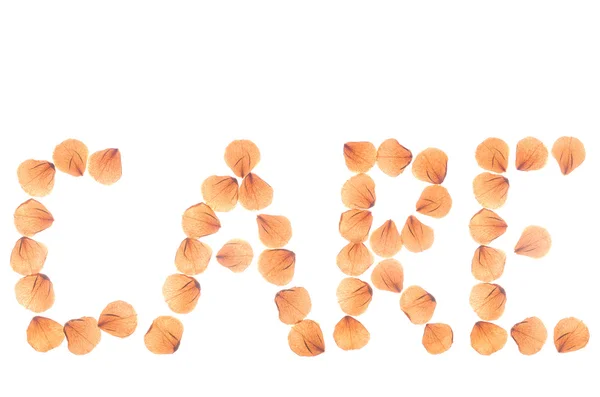 Word CARE arranged from dry real rose petals. — Stock Photo, Image