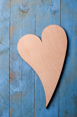 Ahşap kalp mavi ahşap zemin üzerinde.