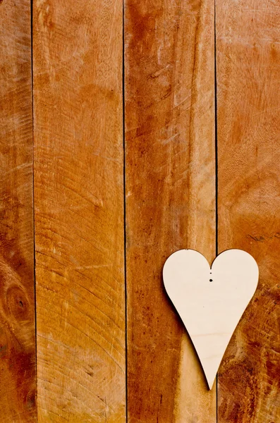 Wooden heart on brown wooden backdrop. — Stock Photo, Image