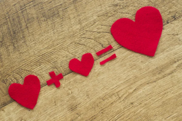 Fall in love. Equation, heart plus hart equal  big red hart. Wooden background. — Stockfoto