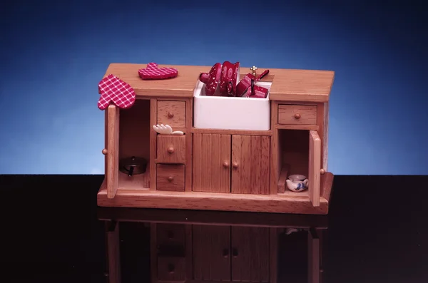 Detalhe da casa de boneca retro mobiliário de cozinha, armário com pia no fundo preto e azul . — Fotografia de Stock