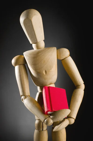 Homme en bois tenant livre rouge . — Photo