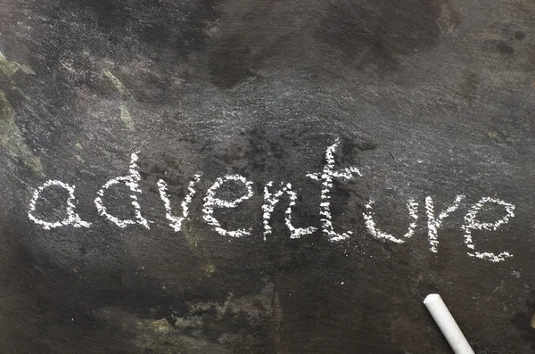 The word adventure written with chalk on black stone. — Stock Photo, Image