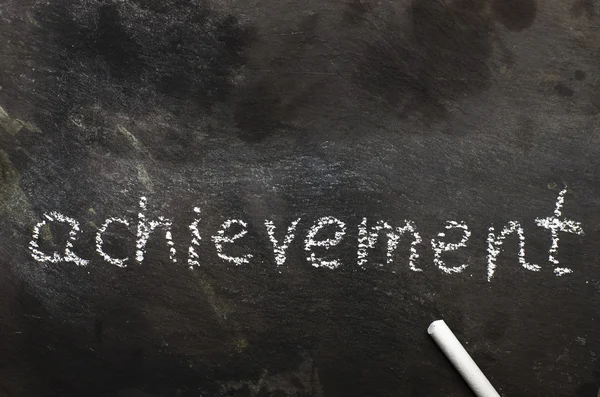 The word achievement written with chalk on black stone. — Stock Photo, Image