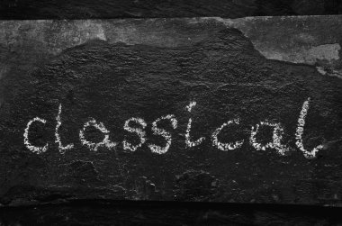 Kara taş üzerine tebeşir ile yazılı klasik kelime.