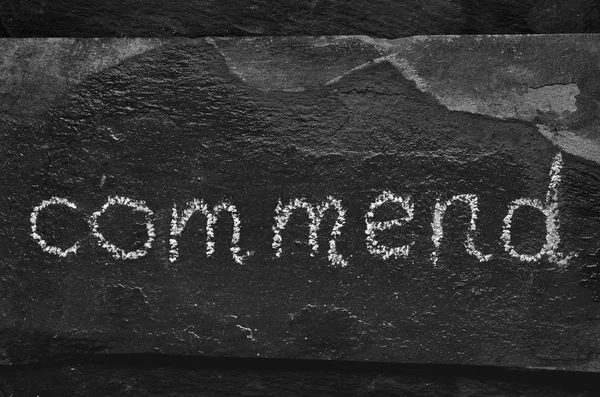 Het woord Commend geschreven met krijt op zwarte steen. — Stockfoto