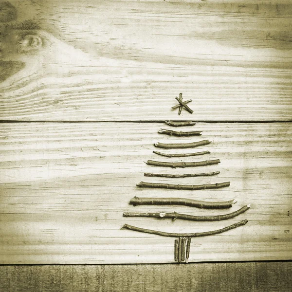 Weihnachtsbaum aus Holzzweigen auf grünem, hölzernem Hintergrund — Stockfoto