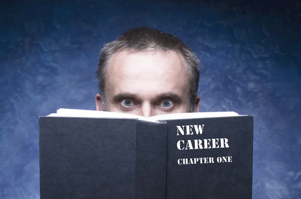 NEW CAREER chapter one written on the cover of the book, mature man being focused and hooked by book, man reading open book — Stock Photo, Image