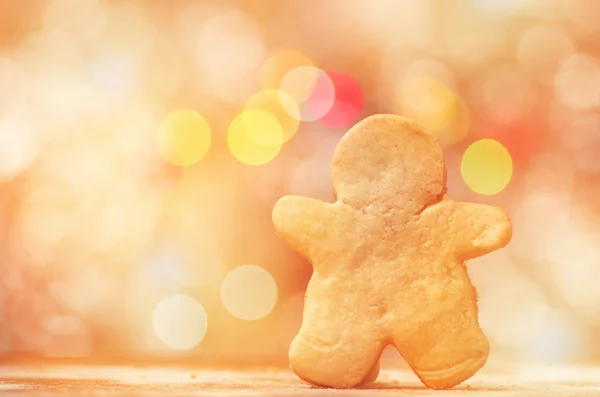 Cookie perník muž na červené a žluté holiday bokeh. Abstraktní Vánoční pozadí — Stock fotografie