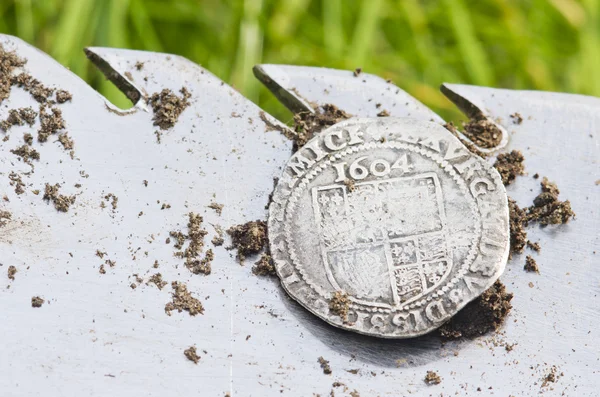 Antigua moneda de plata martillada expuesta en una pala, encontrada en la vida excavada por un detector de metales . — Foto de Stock