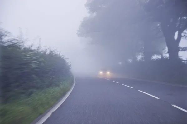 Car on the road in the fog. Autumn landscape. — Stock Photo, Image