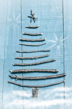Noel ağacı ahşap, mavi zemin üzerine kuru sopa yapılmış. Kar ve kar flaks görüntü. Noel ağacı süsleme.