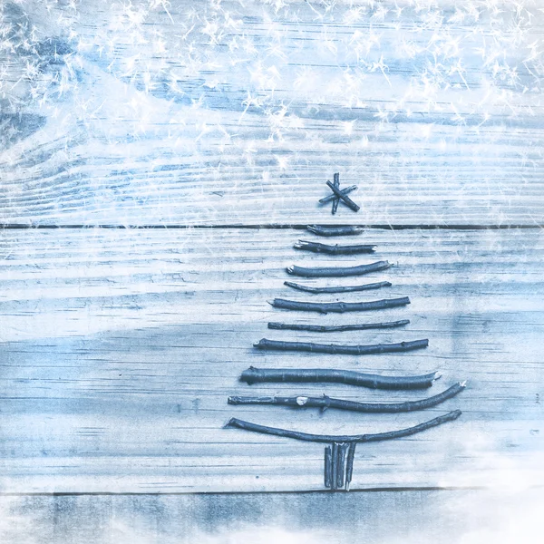 Albero di Natale realizzato con bastoncini asciutti su sfondo di legno blu. Immagine di fiocchi di neve e neve. Ornamento albero di Natale . — Foto Stock