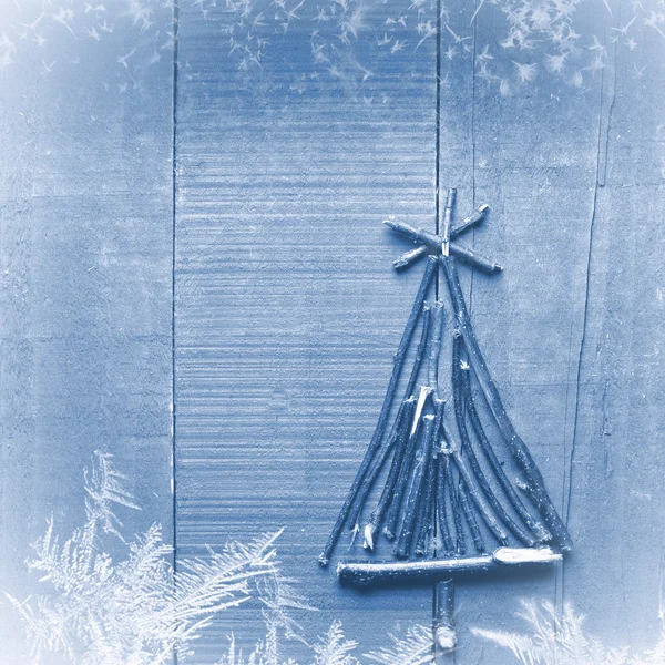 Weihnachtsbaum aus trockenen Stöcken auf blauem Holzgrund. Schnee und Schneeflocken Bild. Christbaumschmuck. — Stockfoto