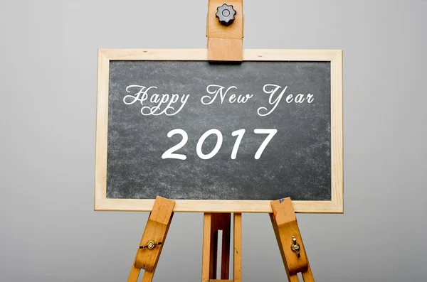 Frohes neues Jahr 2017 geschrieben auf schwarzer Tafel, Staffelei-Malerei. — Stockfoto