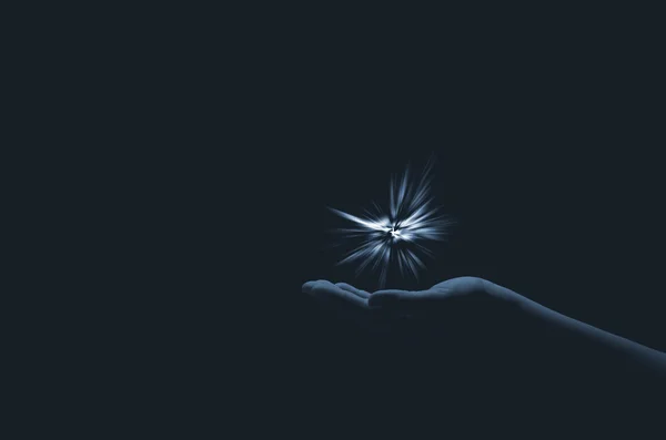 Chispa de esperanza en una mano de mujer sobre fondo oscuro. La luz de la fe . —  Fotos de Stock
